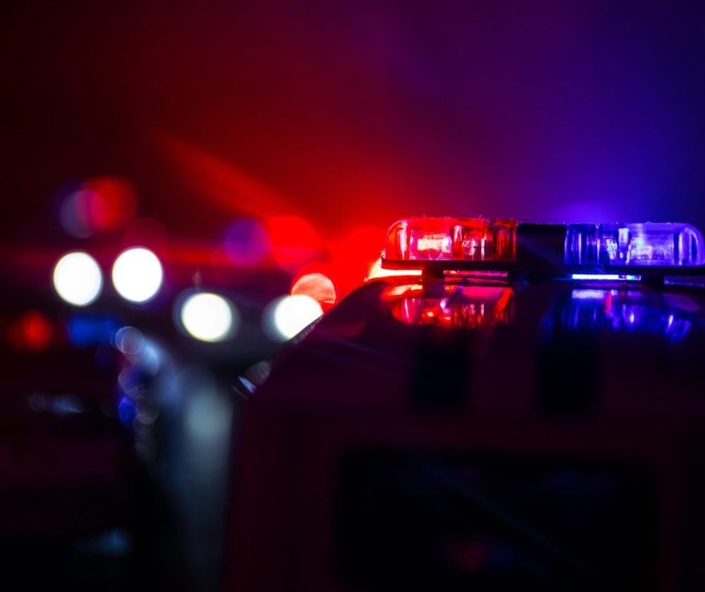 Police Car Police car chasing a car at night with fog background. 911 Emergency response police car speeding to scene of crime. Selective focus